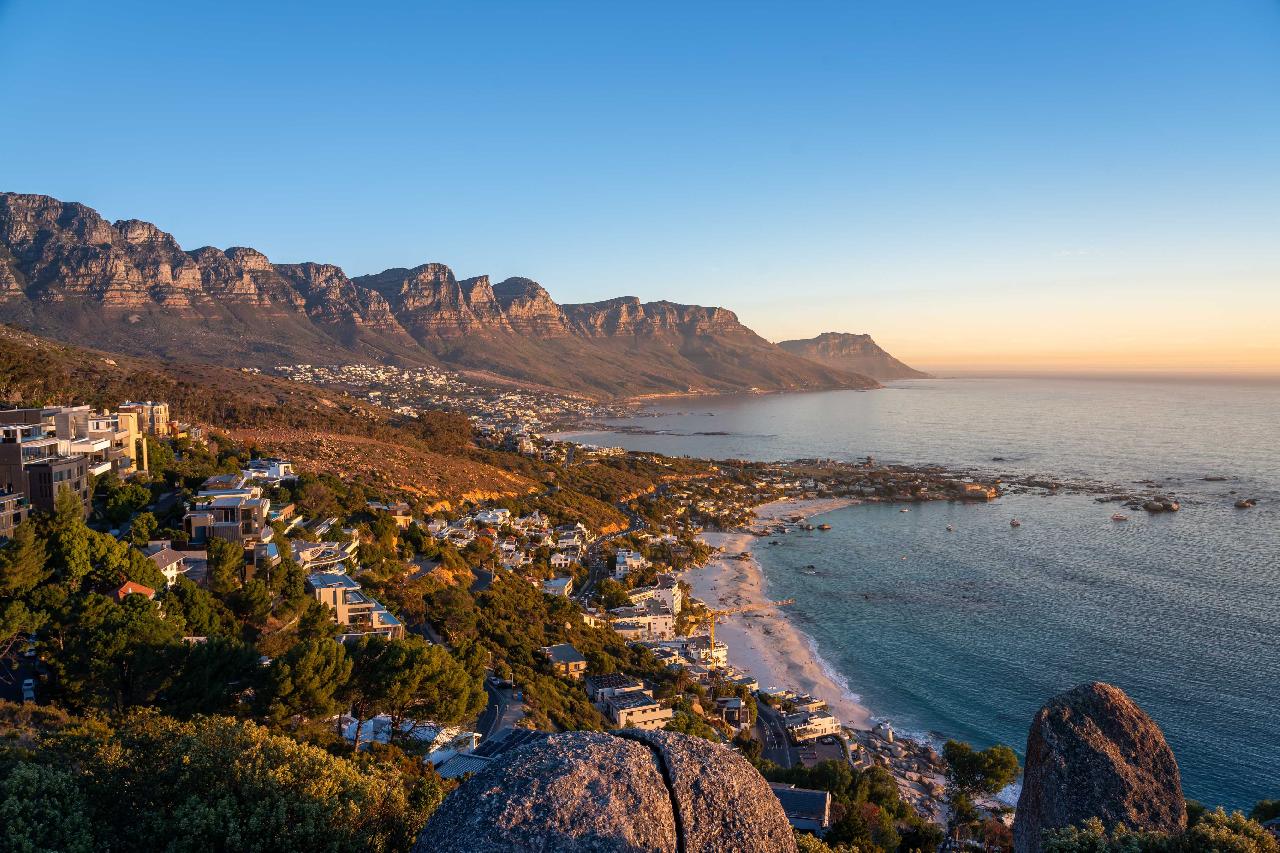 Ez a festői táj a Tábla-hegyet (Table Mountain) és a Camps Bay strandot mutatja be a dél-afrikai Fokvárosban. - Z(s)eppelin utazás