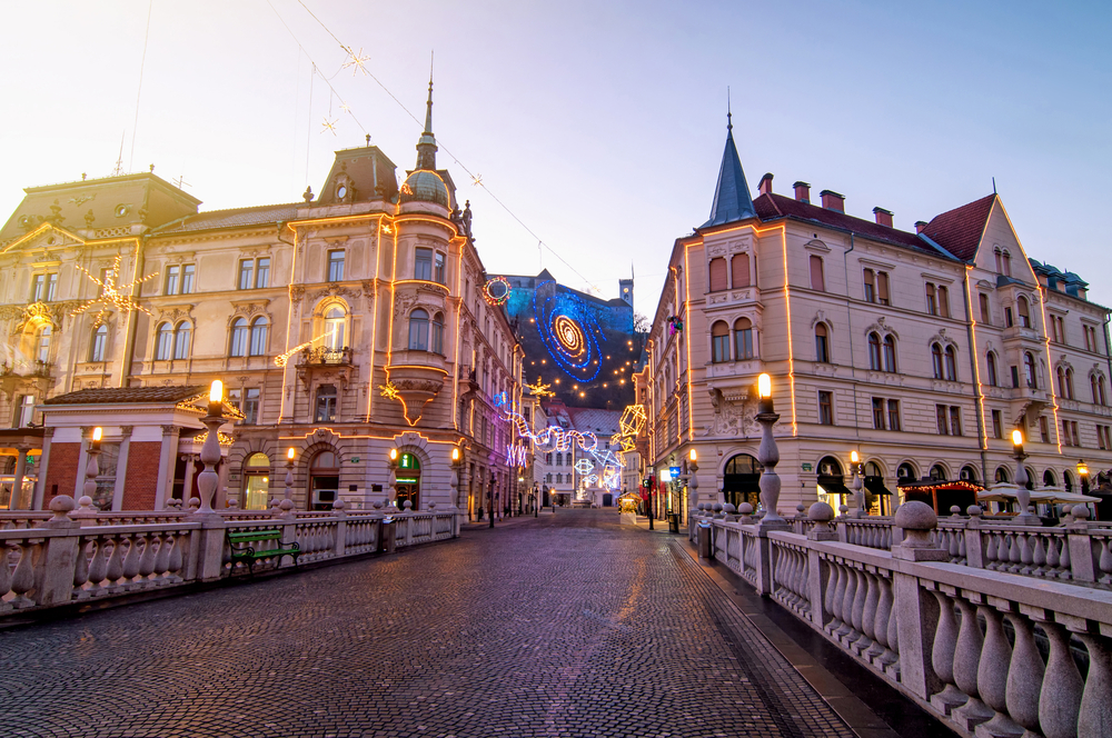 A képen Ljubljana ikonikus Hármas hídja (Tromostovje) látható a háttérben a ljubljanai várral. - Z(s)eppelin utazás