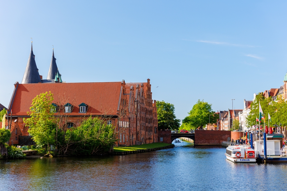 Ez a kép a Lübecker Holstentor-t, Lübeck híres középkori városkapuját ábrázolja a Trave folyó partján.  - Z(s)eppelin utazás