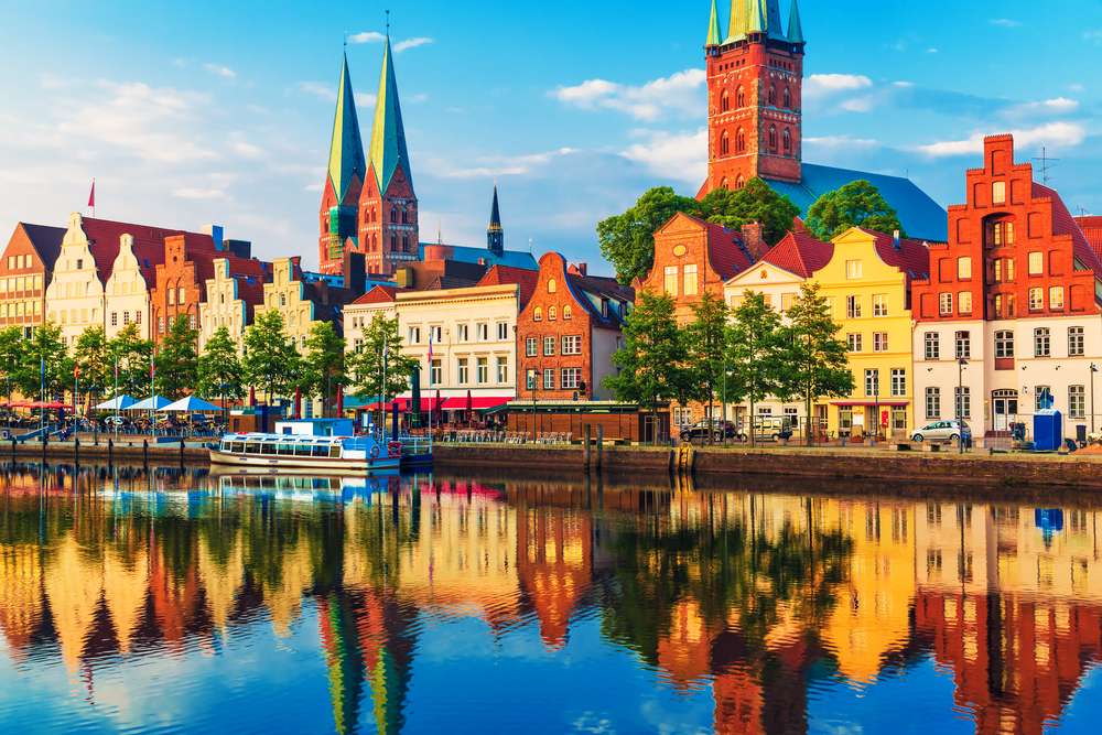 Ez a kép a németországi Lübeck történelmi óvárosát ábrázolja a Trave folyó partjáról fotózva. - Z(s)eppelin utazás