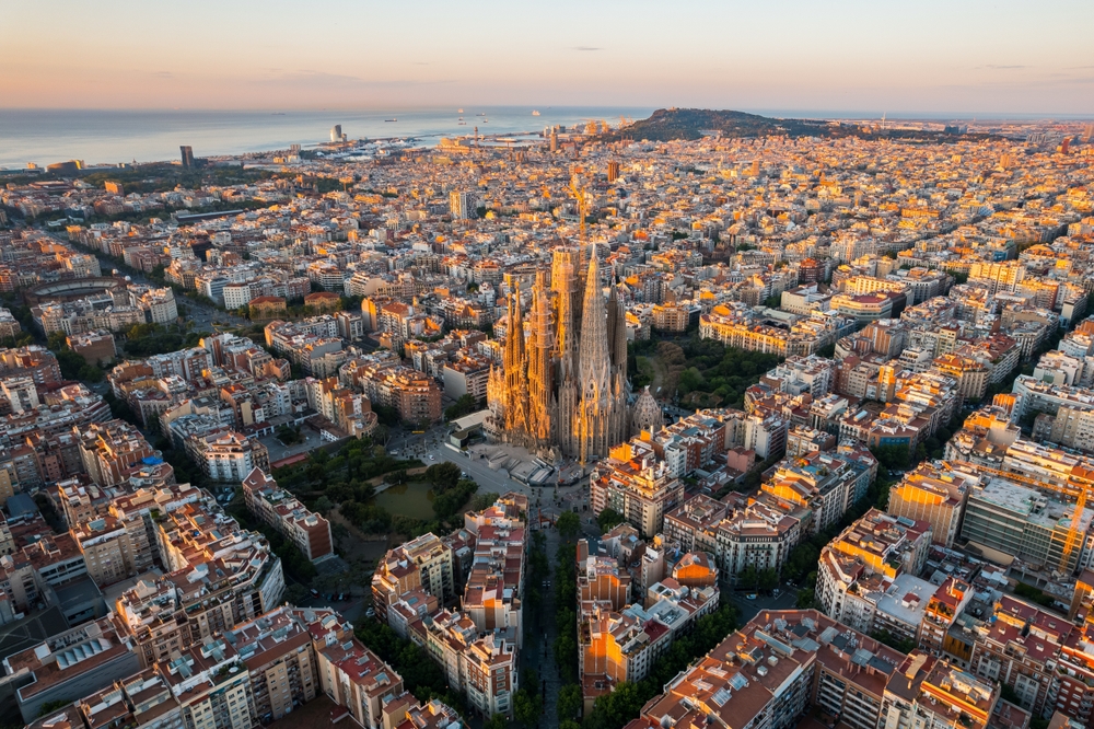 A képen a Sagrada Família és Barcelona városképe látható napkeltekor.  - Z(s)eppelin utazás