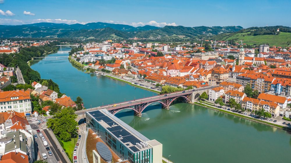 A kép Maribor városát ábrázolja Szlovéniában, a Dráva folyó mentén.  - Z(s)eppelin utazás